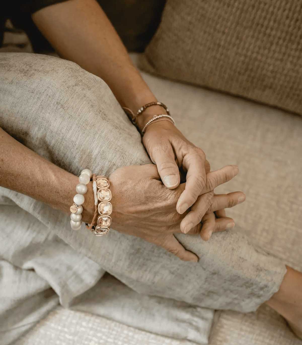 Gefaltete Hände mit Armbändern