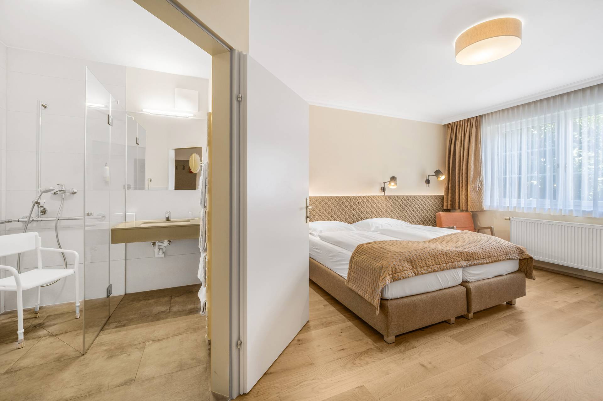 Barrierefreies Zimmer mit Blick ins Bad mit Duschsitz