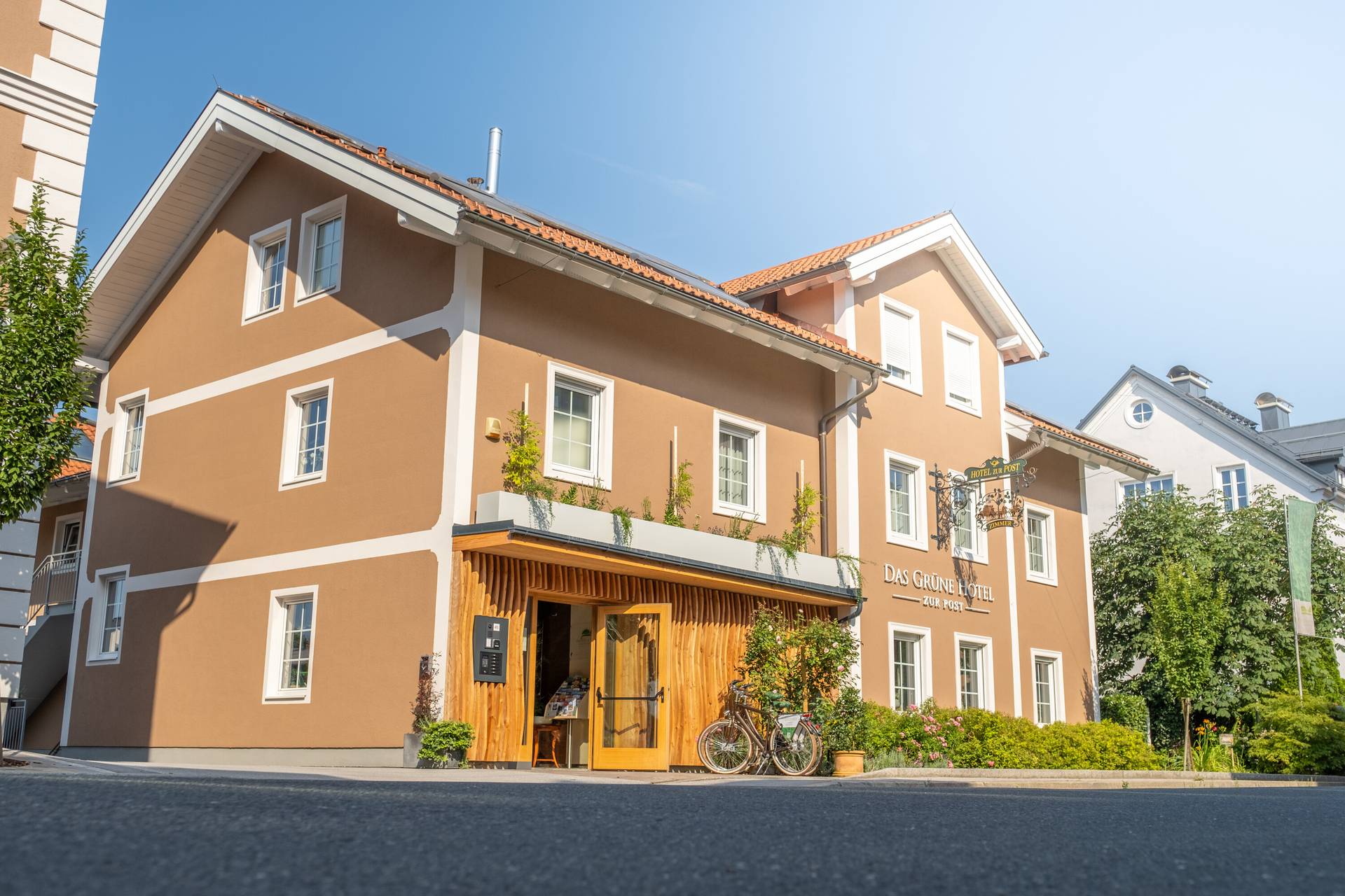 Das Grüne Hotel zur Post mit Holzeingang und begrünter Fassade