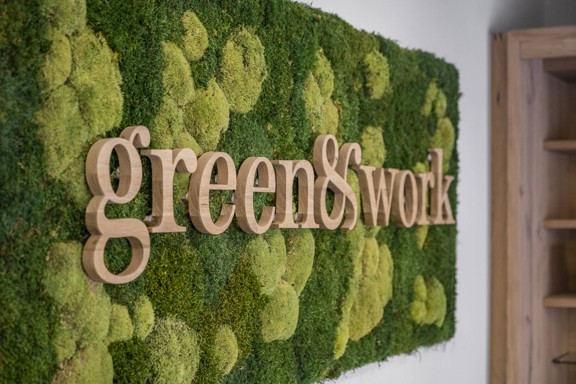 Holzschriftzug „green & work“ auf der Mooswand im Seminarbereich