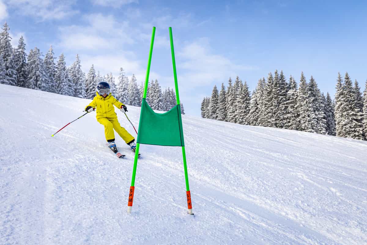 Kind in Gelb fährt auf grünes Tor zu